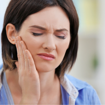 Woman touching her jaw with a pained expression